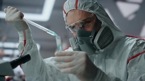 Scientist Drops Liquid Into Test Tube in Lab