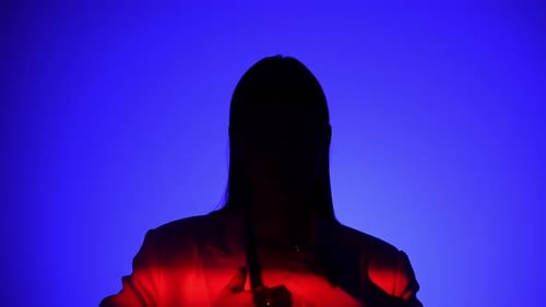 Une personne mystérieuse avec un effet de lumière bleu et rouge spectaculaire