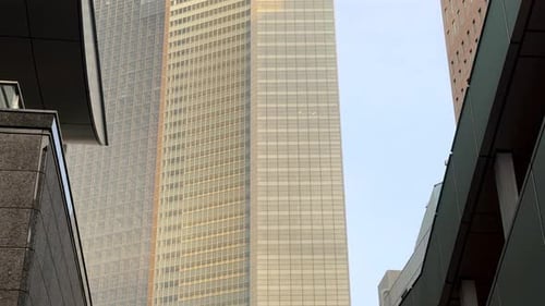 Tall modern skyscraper reflecting the sunset sky in an urban cityscape