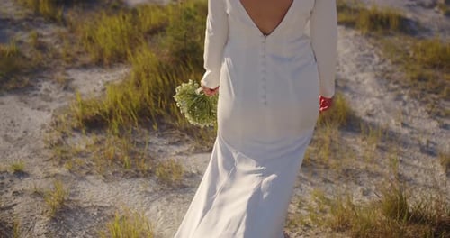 The bride in a festive outfit is photographed in the white rocky mountains