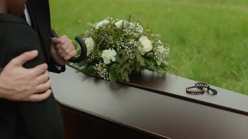 Man Comforts Grieving Relative at Funeral