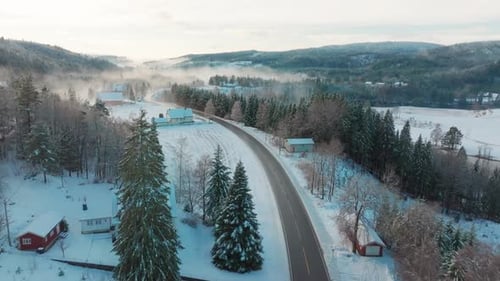 Electric car driving in snowy landscape in norway.