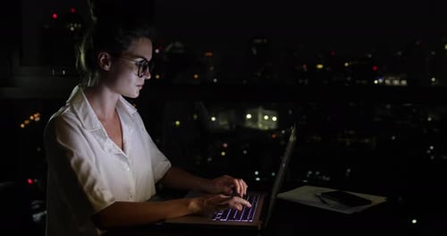 Woman is Working with Laptop at Home During Night