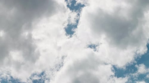 Fluffy White Clouds Floating Across a Blue Sky