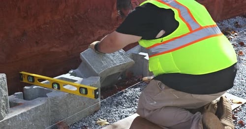 Cuando el contratista estaba instalando un muro de contención de bloques grandes recién construido en la construcción