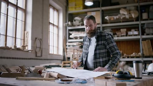 Carpenter Plans Blueprint in Woodshop Workplace