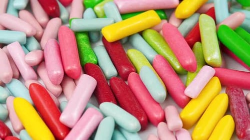 Colorful Candy Pieces Accumulating on White Background