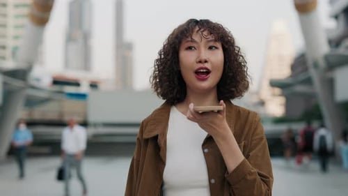 Joyful Asian Girl Record Voice Message While Going Outside Of The City