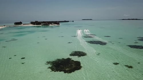 FPV angle following a Jet ski in a lagoon of a Maldives resort. 4K
