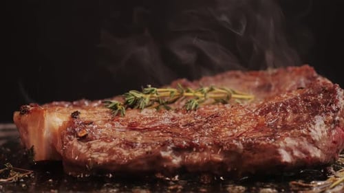 Fresh Marbled Beef with Pepper Salt and Rosemary Closeup Macro Cooking Juicy Steak on Grill with Oil