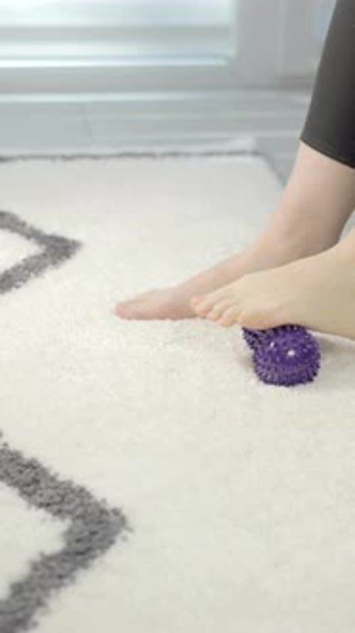 Woman Rolls Foot on Spiky Massage Ball