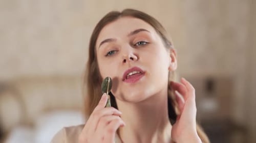 Woman Using Jade Facial Roller for Skincare