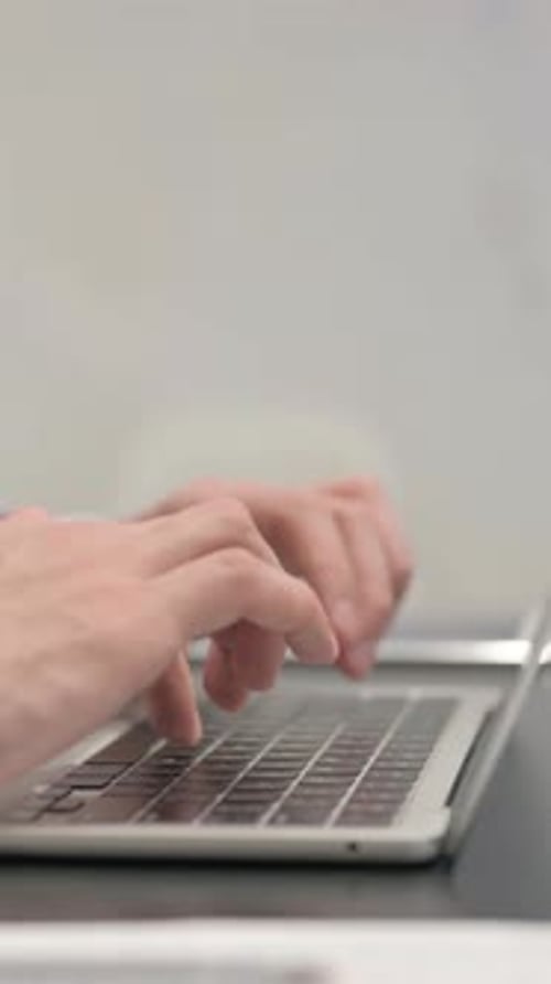 Side View of Businessman Typing on Laptop, vertical video
