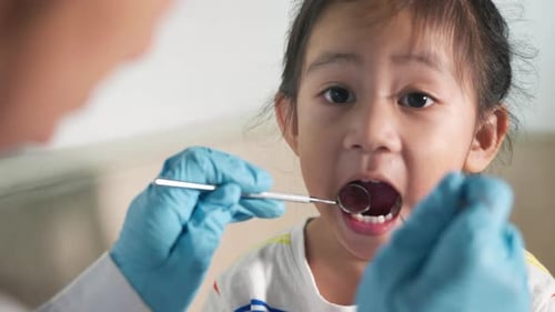 Child's Dental Exam with Mirror by Medical Professional