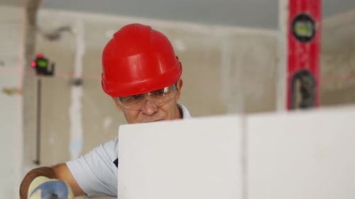 Bricklayer Using Rubber Mallet Hammer to Tap and Level Concrete Blocks Wall Contractor Uses Precise