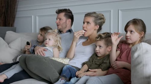 Family Watching TV Together on Comfortable Sofa Indoors