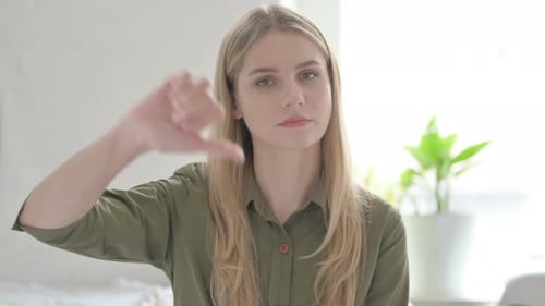Blonde Woman Giving Thumbs Down Gesture