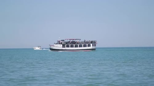 Leute auf dem Boot im See, die am Strand vorbeifahren