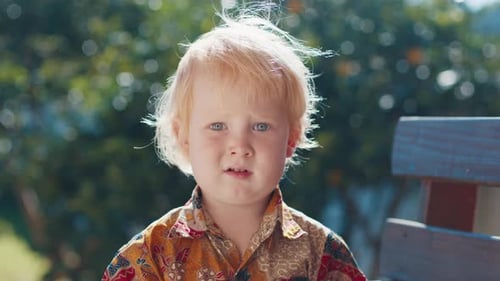 Portrait of the Caucasian Boy with Green Garden on the Background
