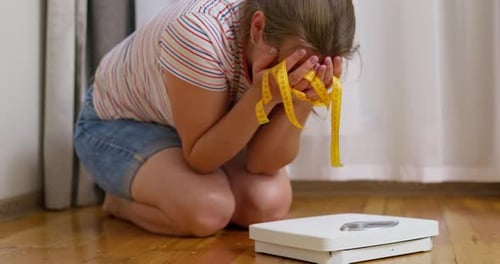 Woman Crouching with Scale and Measuring Tape