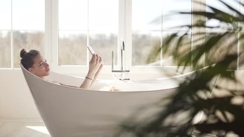 A Beautiful Woman Takes a Selfie and Enjoys Relaxing in a Bubble Bath
