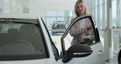 Happy Woman Standing at Dealership Near New Car Handsome Young Female Choosing Transport to Buy
