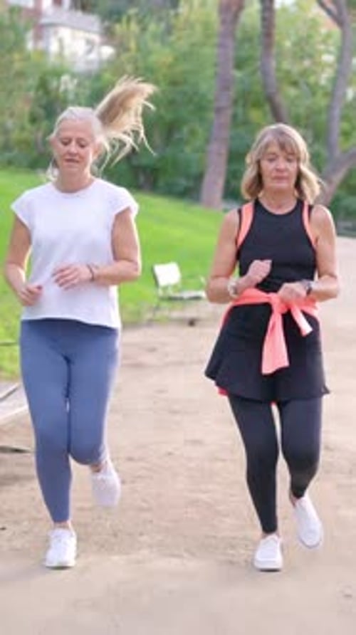 Senior Women Friends Jogging Together in a Park