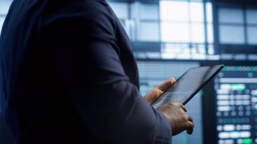 Adult Using Tablet to Analyze Charts and Data