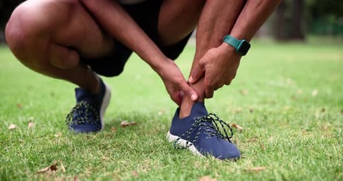Man, athlete and ankle pain on sport field for body workout with hands and anatomy outside