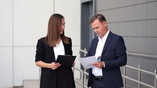 Young Businesswoman and Businessman Discuss Documents