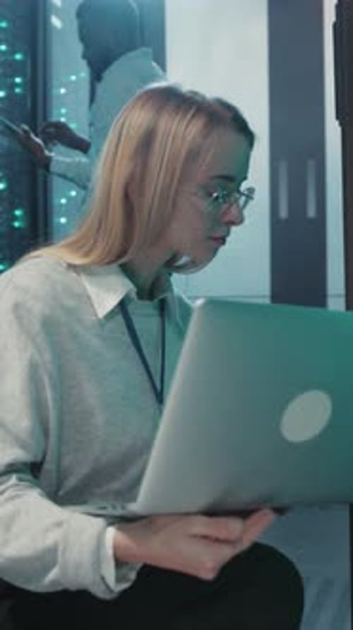 Un jeune professionnel travaille assidûment sur un ordinateur portable dans un environnement moderne axé sur la technologie