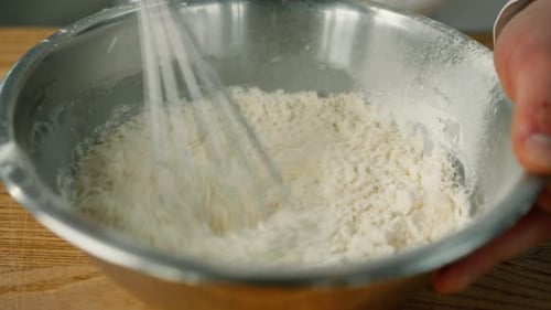 egg in a cooking bowl in a professional kitchen. The process of making pancakes in a restaurant.