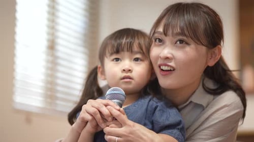 Mother and Child Singing Together into Microphone