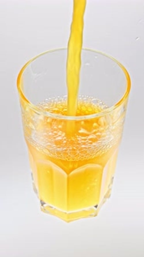 Fresh Yellow Juice Pouring Into Glass