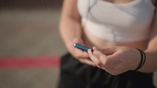Street Performer Adjusting Playlist White Dancer on Street with Headphones and Playlist Female