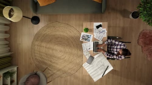 Ansicht von oben, Aufnahme einer behinderten jungen Frau im Rollstuhl, die in ihrem Heimbüro arbeitet, Architekt