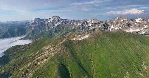 green hills and big snowy mountain ranges