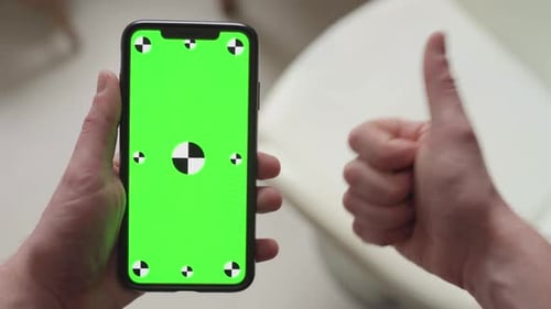 finger pointing on smartphone with green screen display with tracking markers then thumbs up, portra