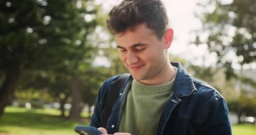 Happy man, student and walking with phone at park for social media or communication