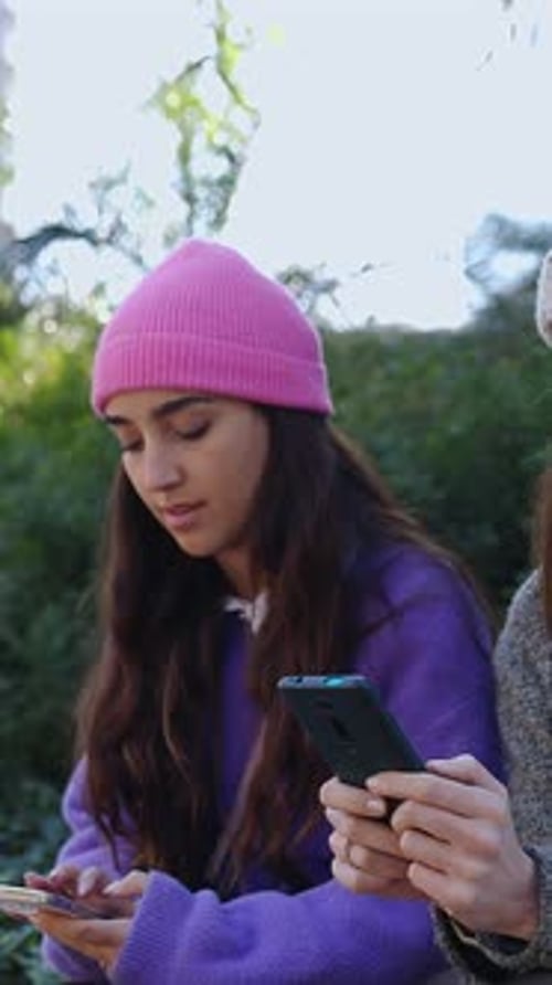 Smiling Women Using Smartphones in Urban Park