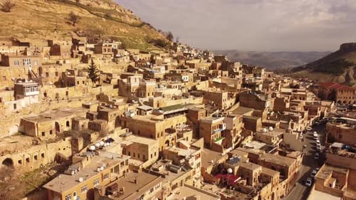 Mardin Turkey rising drone view of hillside old city with stone buildings