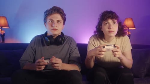 Enthusiastic Young Couple Playing Video Games at Home