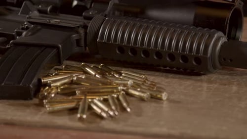 Close dolly in of a lot of ammunition lying in front of AR-15 rifle