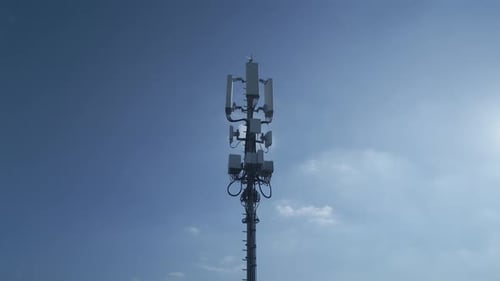 A Telecommunication Tower Standing Tall Under a Clear Bright Blue Sky Lit By Daylight
