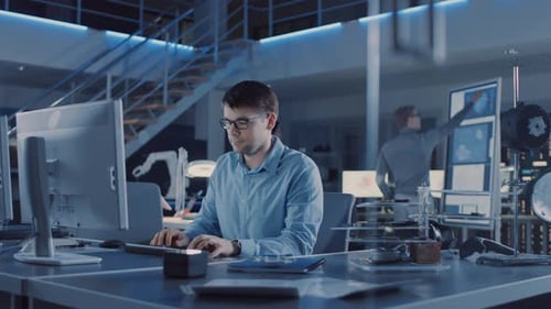 Der Entwicklungsingenieur für Elektronik, der an seinem Schreibtisch sitzt, verwendet einen PC zum Programmieren. Team o