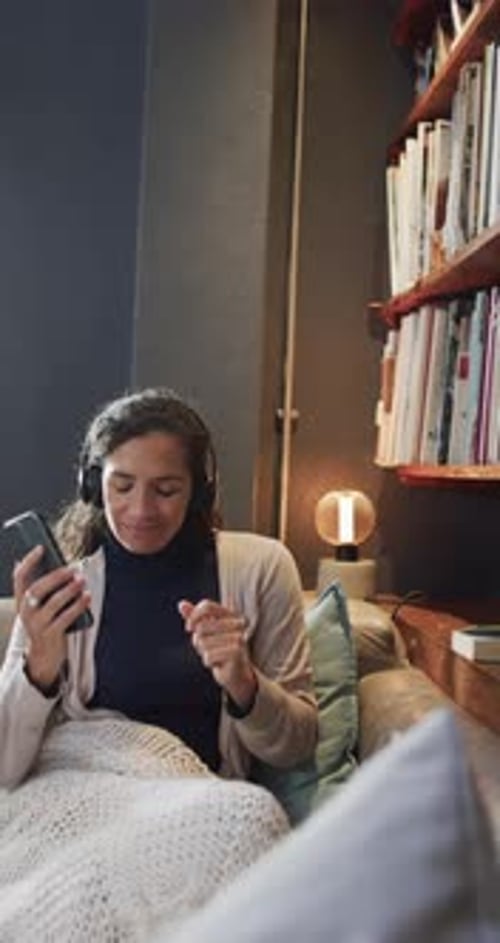 Woman on Couch Listening to Music with Headphones