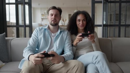 Happy Couple Playing Video Games on Sofa