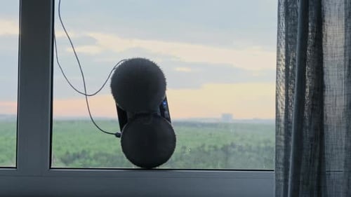 Der weiße Fensterputzroboter verwendet eine Bürste und einen Staubsauger für eine gründliche Reinigung. Der automatische Wind