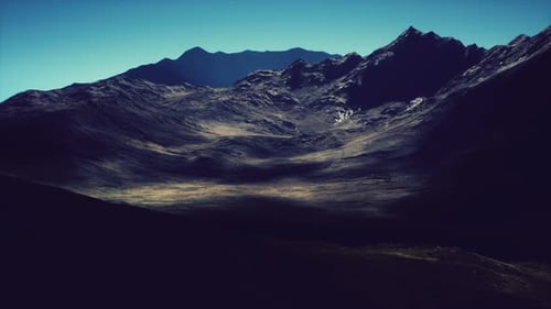 Majestic Mountain Range Under a Clear Sky at Sunset in the Highlands