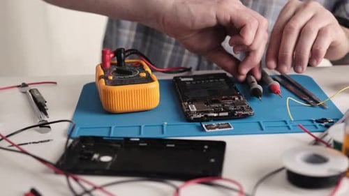 Master Checking Circuit On Microchip Of Broken Smartphone With Digital Multimeter